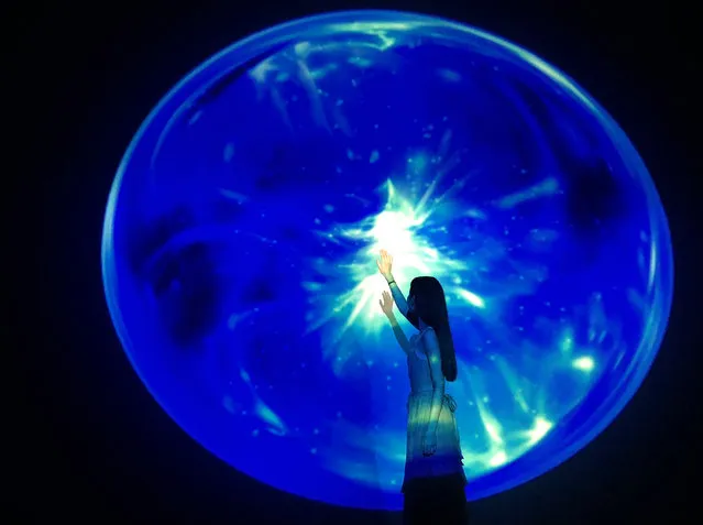 A visitor looks at digital art exhibition “Aquarium by Naked” created by Japanese design and art agency Naked Inc. at Beijing's Guardian Art Center in Beijing, China, 27 July 2018. Helmed by Japanese artist Ryotaro Muramatsu, Naked Inc. aims to bring visitors through a virtual undersea world in an immersive experience produced by a combination of video mapping and light projections. The exhibition runs till 07 September 2018. (Photo by How Hwee Young/EPA/EFE)