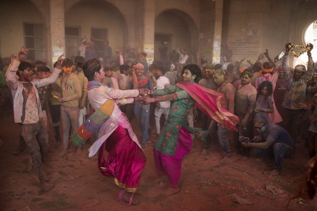 Hindu devotees take part in a traditional gathering during the Lathmar Holi celebrations, the spring festival of colours at a temple in Barsana village of India's Uttar Pradesh state on March 23, 2021. (Photo by Xavier Galiana/AFP Photo)
