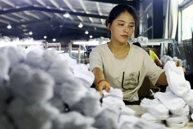 A woman works on socks that will be exported to the US at a factory in Huaibei in China' s eastern Anhui province on August 7, 2018. (Photo by AFP Photo/China Stringer Network)