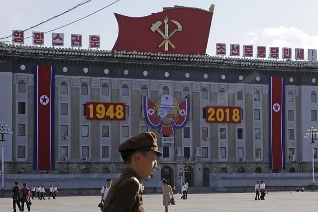 Residents walk past decoration prepared ahead of the 70th anniversary of North Korea's founding day in Pyongyang, North Korea, Friday, September 7, 2018. (Photo by Kin Cheung/AP Photo)