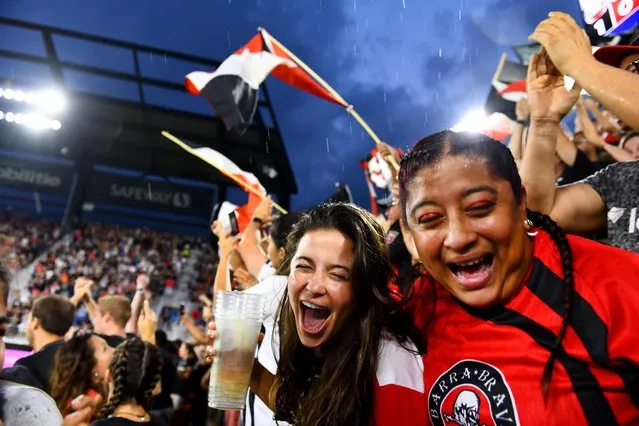 D.C. United fans Sidny Oyola and Yvette Jimenez are showered with beer as fans celebrate the team’s goal against the New England Revolution at Audi Field in Washington on August 19, 2018. (Photo by Katherine Frey/The Washington Post)