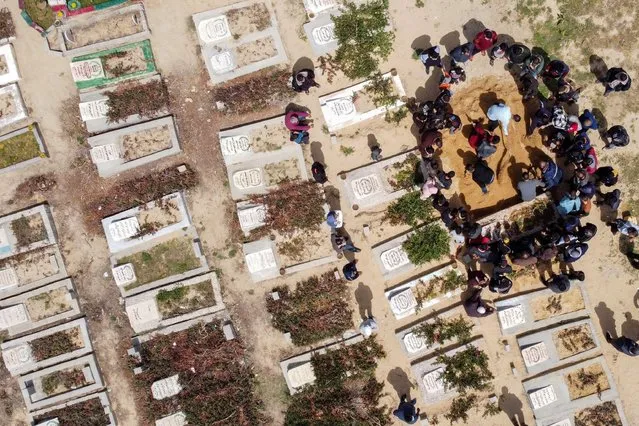 A picture taken with a drone shows Palestinians burying the body of a man, who died after contracting the coronavirus, at a cemetery in the central Gaza Strip, April 6, 2021. (Photo by Mohammed Salem/Reuters)