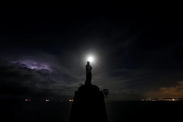 A statue of the Madonna overlooks the sea as the supermoon rises and a lightning storm strikes off the coast at Marfa Ridge, in the north of Malta, November 14, 2016. (Photo by Darrin Zammit Lupi/Reuters)