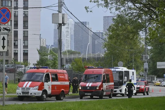 Police and emergency vehicles parked at the side of the wreckage of the drone fell near the Karamyshevskaya embankment to the after a reported drone attack in Moscow, Russia, on Friday, August 11, 2023. The Mayor of Moscow, Sergei Sobyanin said a drone fell in western Moscow after it was shot down by air defense systems. Sobyanin said no-one was hurt when the drone fell near Karamyshevskaya embankment and that no serious damage was caused. Russian social media channels shared videos of what they said was a drone flying low above Moscow and of smoke rising above the Moscow river. (Photo by AP Photo/Stringer)