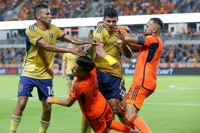After getting a red card for knocking down Houston Dynamo's Luis Caicedo, Real Salt Lake defender Brayan Vera, top center, punches Dynamo midfielder Amine Bassi (8) as Real Salt Lake's Maikel Chang (16) and Dynamo's Artur, right, try to hold Vera back during extra time in the second half of a U.S. Open Cup soccer semifinal Wednesday, August 23, 2023, in Houston. (Photo by Michael Wyke/AP Photo)