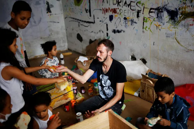Jorge (C), 31, who is among members of lesbian, gay, bisexual and transgender (LGBT) community, that have been invited to live in a building that the roofless movement has occupied, teaches children to draw, in downtown Sao Paulo, Brazil, November 15, 2016. (Photo by Nacho Doce/Reuters)