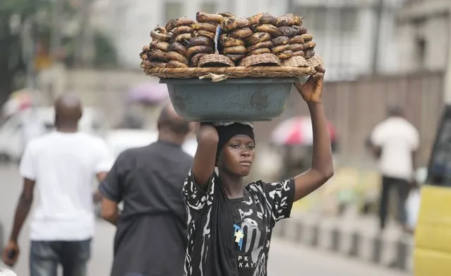 A woman sells smoked fish on the streets of Lagos, Nigeria, Tuesday, September 5, 2023. (Photo by Sunday Alamba/AP Photo)