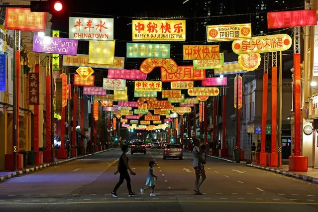 People cross a street decorated with banner like lanterns during the Mid-Autumn Festival at Chinatown on September 20, 2020 in Singapore. (Photo by Suhaimi Abdullah/Getty Images)