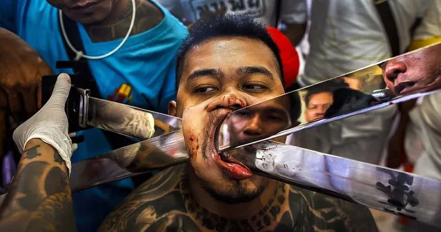 A devotee of the Chinese Bang Neow Shrine has blades pierced through his cheek before the beginning of a street procession during the annual vegetarian festival in Phuket, Thailand. The festival, featuring face-piercing, spirit mediums and strict vegetarianism celebrates the local Chinese community's belief that abstinence from meat and various stimulants during the ninth lunar month of the Chinese calendar will help them obtain good health and peace of mind. (Photo by Athit Perawongmetha/Reuters)