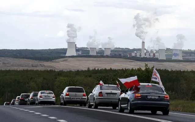 Cars drive slowly to block a border between Czech Republic and Poland near the Turow mine near Bogatynia, Poland, Tuesday, May 25, 2021. People in their cars protested against the decision of the European Union's top court on Friday, that ordered Poland to immediately stop extracting brown coal at the Turow mine near the border with the Czech Republic and Germany. (Photo by Petr David Josek/AP Photo)