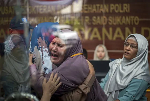 Relatives of a passengers of the crashed Lion Air plane cry at the police hospital in Jakarta, Indonesia, Tuesday, October 30, 2018. Relatives numbed by grief provided samples for DNA tests to help identify victims of the Lion Air plane crash as accounts emerged of problems on the jet's previous flight including rapid descents that terrified passengers. (Photo by Fauzy Chaniago/AP Photo)