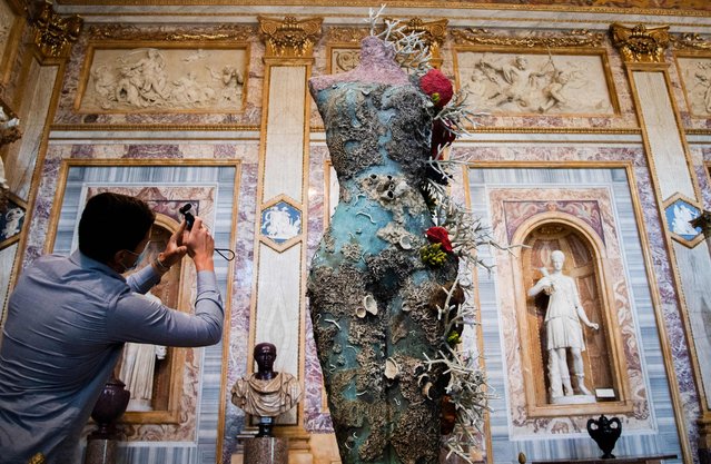 A visitor takes photos of “Grecian Nude” by British artist Damien Hirst, as part of the exhibition “Archaeology Now” at Galleria Borghese in Rome on June 07, 2021. The exhibition, running through June 08 – November 07, 2021, features over 80 works from Hirst’s Treasures from the Wreck of the Unbelievable series, displayed throughout the museum alongside ancient masterpieces. (Photo by Tiziana Fabi/AFP Photo)