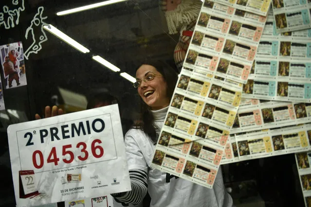 Monica celebrates in her lottery office after selling the second Christmas lottery prize “El Gordo” with the number 04536, in Pamplona, northern Spain, Thursday, December 22, 2016. Celebrations were guaranteed Thursday in Madrid where tickets bearing the top prize number of 66513 in Spain's Christmas lottery, “El Gordo” were sold. (Photo by Alvaro Barrientos/AP Photo)