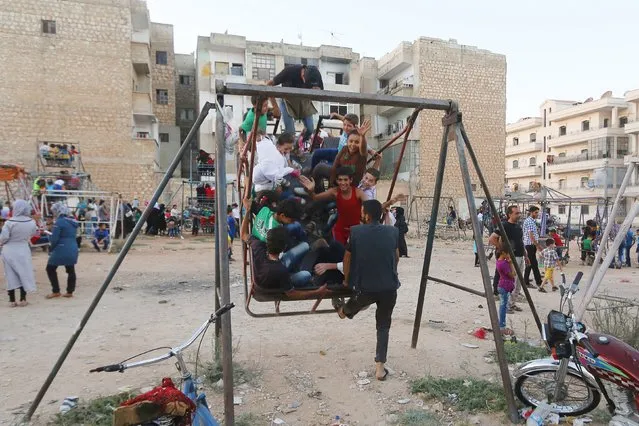 Children play at a makeshift playground during the Muslim festival of Eid-al-Adha in Idlib city, Syria September 24, 2015. (Photo by Ammar Abdullah/Reuters)