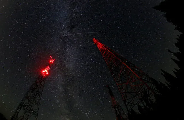 A trace of the Perseid meteor is seen in the moonless night sky over telecommunication masts in the Siberian Taiga area in Krasnoyarsk Region, Russia on August 19, 2018. (Photo by Ilya Naymushin/Reuters)