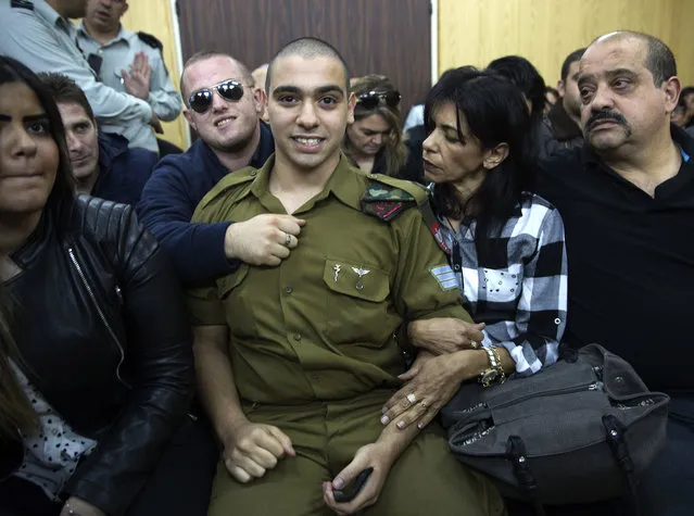 Israeli solider Sgt. Elor Azaria waits with his parents for the verdict inside the military court in Tel Aviv, Israel on Wednesday, January 4, 2017. An Israeli military court is set to deliver the verdict in the case of the soldier tried for manslaughter for the death of a wounded Palestinian attacker. (Photo by Heidi Levine, Pool via AP Photo)