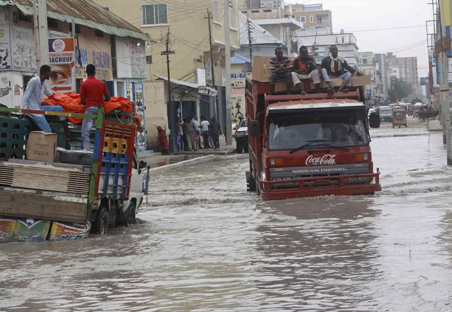 Vehicles try to maneuver through flood water caused by heavy rain, in Mogadishu, Saturday, November 11, 2023. (Photo by Farah Abdi Warsameh/AP Photo)