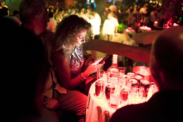 A clubgoer checks her phone inside the Baby O nightclub on April 2, 2015 in Acapulco, Mexico. (Photo by Jonathan Levinson/The Washington Post)