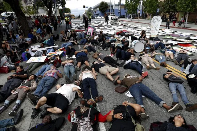 People stage a “die-in” in the middle of the road after carrying coffins during a march to commemorate the more than 617 people they say have been killed by law enforcement in LA County since 2000, in Los Angeles, California April 7, 2015. (Photo by Lucy Nicholson/Reuters)