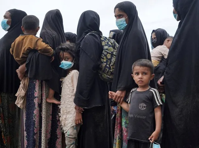 Rohingya women with children queue for transport to a shelter, as they arrive in Muara Tiga, Pidie Regency, Aceh province, Indonesia on November 14, 2023. (Photo by Hidayatullah Tajuddin/Reuters)