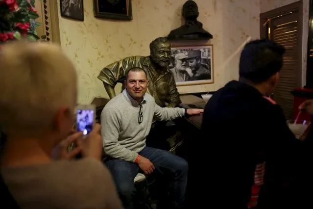 Tourists pose in front of a bronze statue of the late Nobel prize-winning author Ernest Hemingway at the “Floridita” bar in Havana in this January 18, 2016 picture. (Photo by Alexandre Meneghini/Reuters)