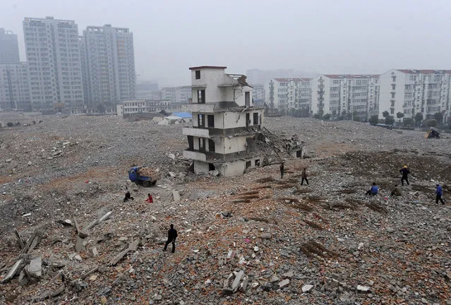 A partially-demolished “nail house”, the last house in the area, is seen at a construction site in Hefei, Anhui province, China, February 2, 2010. The owner of the house was attempting to seek more compensation before agreeing to the demolition of their home, local media reported. (Photo by Reuters/Stringer)