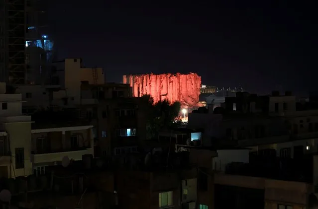 The grain silo that was damaged during Aug. 4, 2020 explosion in Beirut's port, is illuminated on the eve of blast anniversary, in Beirut, Lebanon on August 3, 2021. (Photo by Emilie Madi/Reuters)