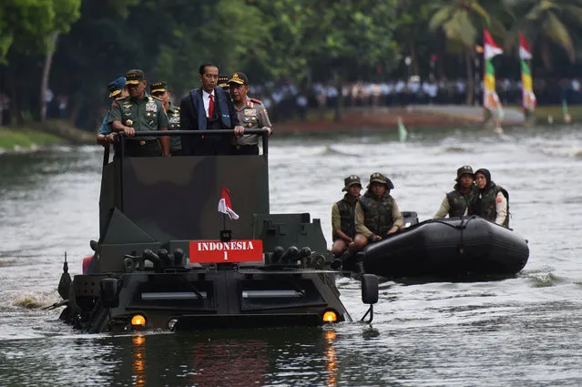 (L-R) Indonesia Military Chief Gatot Nurmantyo, Indonesia President Joko Widodo, and Indonesia Police Chief Tito Karnavian stand on a military amphibious vehicle Anoa 2 while crossing a lake at a military headquarters in Jakarta, Indonesia, January 16, 2017. (Photo by Akbar Nugroho Gumay/Reuters/Antara Foto)