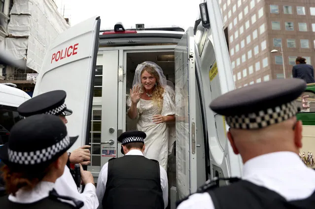An activist wearing a wedding dress reacts as she stands in the police vehicle during an Extinction Rebellion protest, in London, Britain, August 31, 2021. (Photo by Tom Nicholson/Reuters)