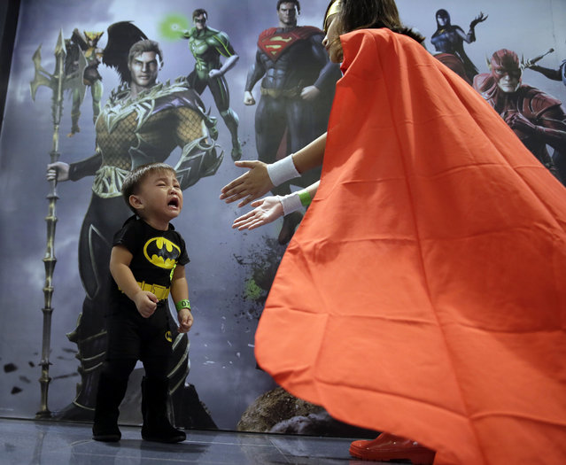 Kirk Mathew Garcia, dressed as Batman, cries as his sister Cristina, 11, dressed as Wonder Woman, prepares to carry him as they join Filipino fans of DC comics super heroes during an attempt to establish a world record for the most number of fans wearing their super heroes costumes Saturday, April 18, 2015 at suburban Quezon city, northeast of Manila, Philippines. (Photo by Bullit Marquez/AP Photo)
