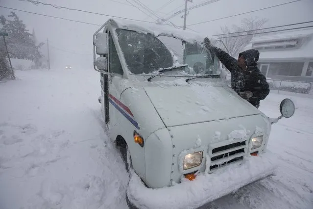 US postal worker Daniel DeCusace tries to clear the snow from his truck in Warwick, Rhode Island, USA, 09 February 2017 as a major snowstorm hits the region. (Photo by Lisa Hornak/EPA)