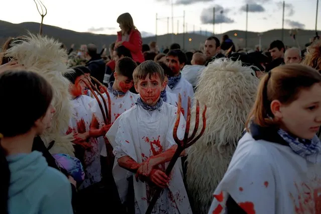 Children dressed as Momotxorros, half bull, half man figures wrapped in blood-spattered sheepskins, take part in carnival celebrations in Alsasua, northern Spain on February 13, 2024. (Photo by Vincent West/Reuters)