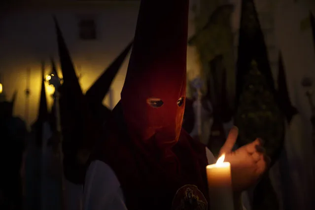 Penitents hold candles as they take part in a Holy Week procession in Jerez de la Frontera, Spain, Monday, March 30, 2015. Hundreds of processions take place throughout Spain during the Easter Holy Week. (Photo by Daniel Ochoa de Olza/AP Photo)