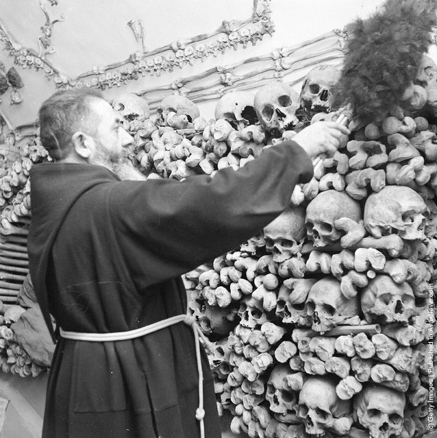A monk dusts down the remains of his dead comrades in the tombs and the catacombs of a Capuchin monastery in Rome