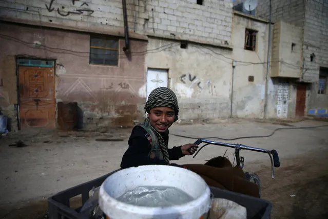 A boy transports water on a bicycle in the rebel-held besieged Douma neighbourhood of Damascus, Syria February 15, 2017. (Photo by Bassam Khabieh/Reuters)