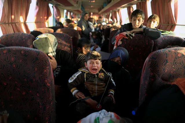 A boy, who just fled a village controlled by Islamic State  fighters cries as he sits with his family inside a bus before  heading to the camp at Hammam Ali  south of Mosul, Iraq February 22, 2017. (Photo by Zohra Bensemra/Reuters)