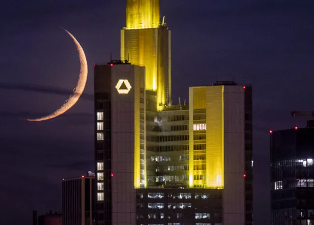 The crescent moon sets behind the Commerzbank building in Frankfurt, Germany, late Saturday, September 19, 2020. (Photo by Michael Probst/AP Photo)