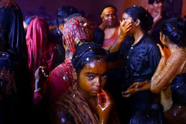 A girl looks on as Hindu devotees take part in Huranga, a game played between men and women a day after Holi, at Dauji temple near the northern city of Mathura, India on March 26, 2024. (Photo by Sharafat Ali/Reuters)