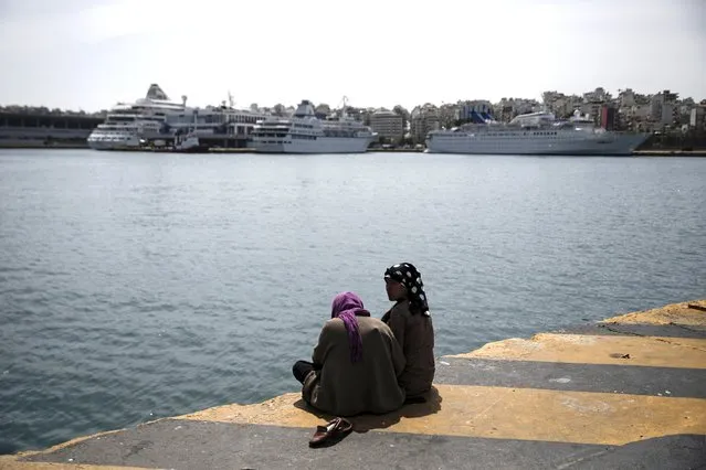 Two Afghan migrants sit at the dock next to a makeshift camp for refugees and migrants at the port of Piraeus, near Athens, Greece April 3, 2016. (Photo by Alkis Konstantinidis/Reuters)