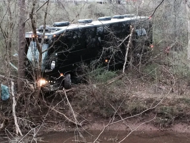 A tour bus for musician Gregg Allman's band rests against a tree near a creek after veering off Interstate 77 Wednesday morning, April 6, 2016, near Goldtown, W.Va. A tour spokesman for Allman's band says three crew members have been injured. The bus was headed to a concert Wednesday at the Clay Center in Charleston, about 20 miles south of Goldtown. Clay Center spokeswoman LeAnn Cain said the concert is still on. Allman wasn't on the bus. (Photo by John Green/WSAZ-TV via AP Photo)