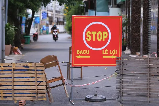 An alley is blocked with chairs and wood planks in Vung Tau, Vietnam, Monday, September 13, 2021. In Vung Tau, just outside Ho Chi Minh city, streets are sealed and checkpoints are set up to control the movement of people. Barbed wire, door panels, steel sheets, chairs and tables are among materials being used to fence up alleys and isolate neighborhoods. (Photo by Hau Dinh/AP Photo)