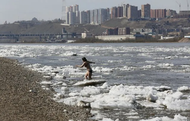 A woman walks out after bathing during an ice drift on the Yenisei river in Krasnoyarsk, Siberia, Russia, April 20, 2016. (Photo by Ilya Naymushin/Reuters)