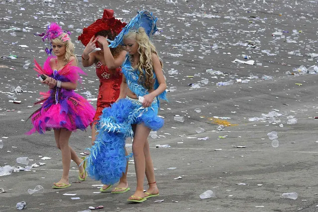 Racegoers walk through litter as they leave on Ladies' Day, the second day of the Grand National horse racing meeting at Aintree, northern England April 4, 2014. (Photo by Toby Melville/Reuters)