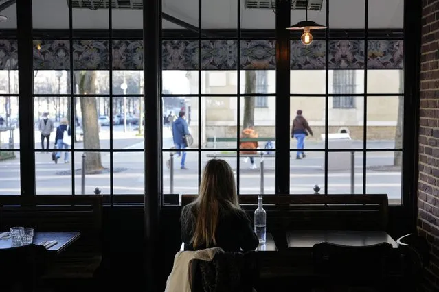 A customer sits in a restaurant, in Paris, Monday, January 24, 2022. Unvaccinated people are no longer allowed in France's restaurants, bars, tourist sites and sports venues. A new law came into effect Monday requiring a “vaccine pass” that is central to the government's anti-virus strategy. (Photo by Thibault Camus/AP Photo)