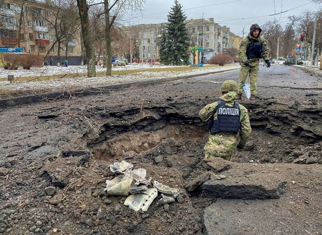 Police officers inspect a crater near a site of a residential building destroyed by a Russian missile strike, amid Russia's attack on Ukraine, in Kramatorsk, Ukraine on February 2, 2023. (Photo by Vitalii Hnidyi/Reuters)