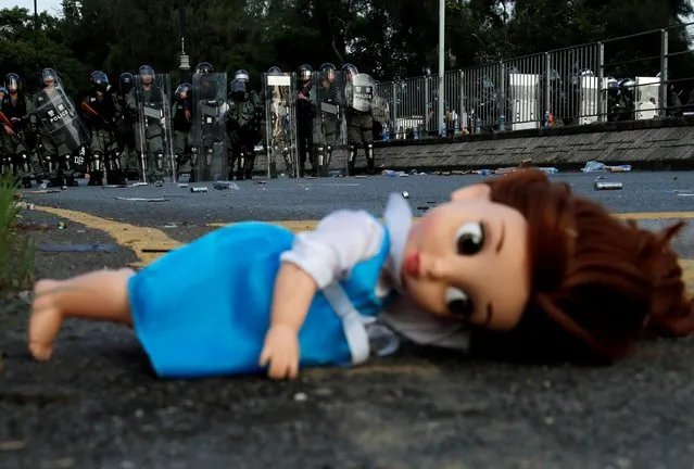 A doll left by the protesters lies on the ground as riot police officers block the street during a demonstration in support of the city-wide strike and to call for democratic reforms at Tai Po residential area in Hong Kong, China, August 5, 2019. (Photo by Tyrone Siu/Reuters)