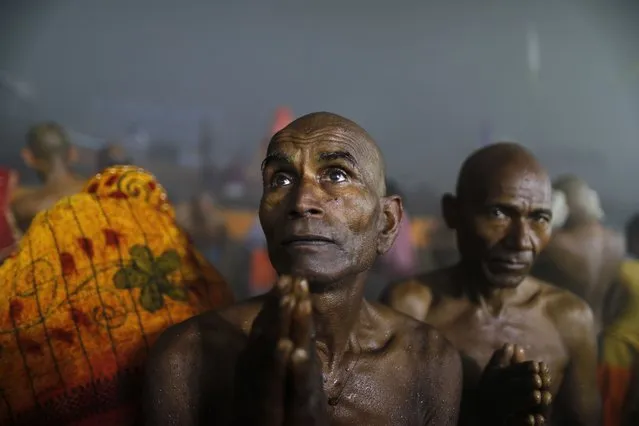 A Hindu pilgrim prays after taking a holy dip at Sangam, the confluence of the rivers Ganges and the Yamuna on “Mauni Amavasya” or new moon day, third and the most auspicious date of bathing day during the annual month long Hindu religious fair “Magh Mela” In Prayagraj, India. Tuesday, February 1, 2022. (Photo by Rajesh Kumar Singh/AP Photo)