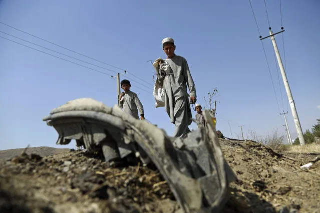 Afghan boys collects the remains of a suicide attacker's vehicle in Kabul, Afghanistan, Wednesday, July 24, 2019. Croatia’s defense ministry said Wednesday that one of three soldiers injured in an apparent attack by a suicide bomber in Afghanistan, has died. The 27-year-old soldier, identified by his initials J.B., died around noon on Wednesday from the injuries he suffered in the attack in Kabul, the ministry statement said. (Photo by Rahmat Gul/AP Photo)
