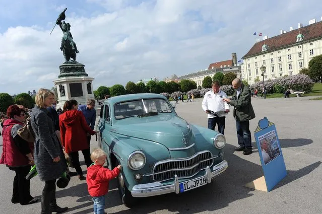 Oldtimer car owner Marek Schramm (2-R) stands next to his “FSO Warszawa” type “M20” car during a stop at the Heldenplatz (Heroes' Square) in downtown Vienna, Austria, 21 April 2014, en route to the canonization of late Pope John Paul II in Rome, Italy. According to the car's registration documents, the vehicle once was owned by Polish Cardinal Karol Wojtyla, who later became Pope John Paul II, registered under the licence plate number “KR 96 13” from 1958 to 1977. (Photo by Herbert Pfarrhofer/EPA)
