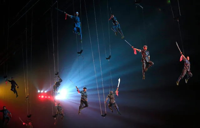 Actors dressed as Communist Red Army soldiers perform hanging from wires during “Mao Zedong Comes from China”, a show based on the former Chinese Communist leader's life at an outdoor theater in Shaoshan, Hunan Province in central China, 27 April 2016. (Photo by How Hwee Young/EPA)